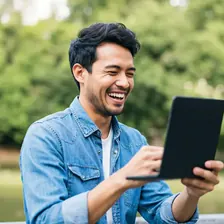 Man laughing during video chat outdoors